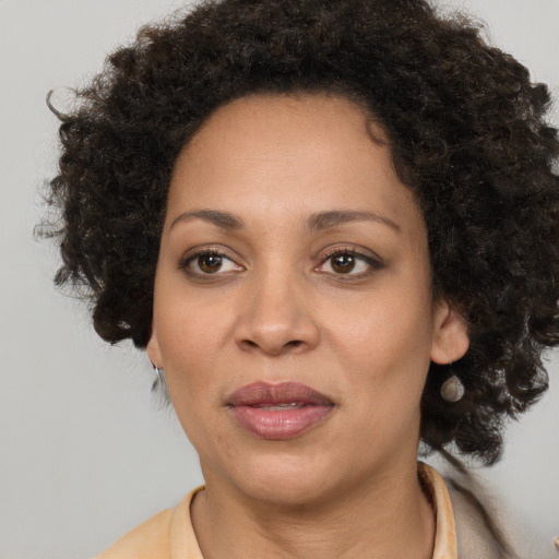 Joyful black adult female with medium  brown hair and brown eyes