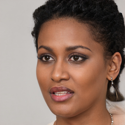Joyful black young-adult female with long  brown hair and brown eyes
