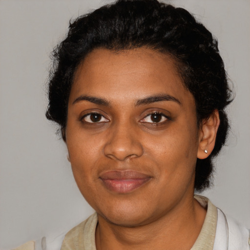 Joyful black young-adult female with short  black hair and brown eyes