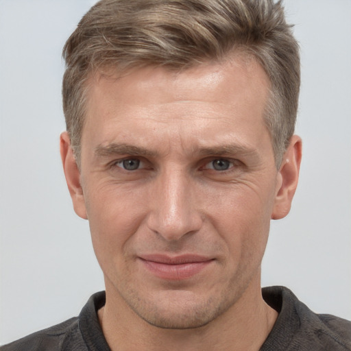 Joyful white adult male with short  brown hair and grey eyes