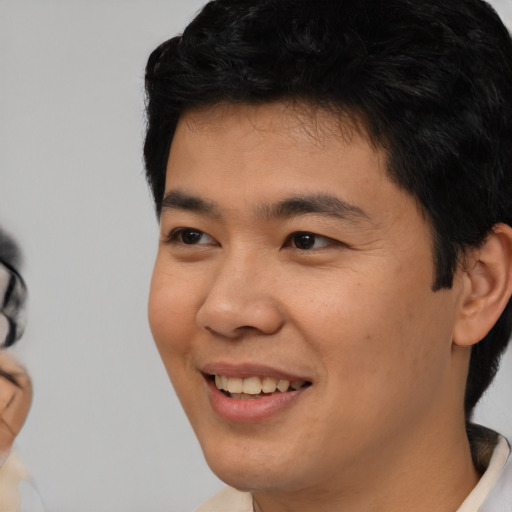 Joyful asian young-adult male with short  black hair and brown eyes