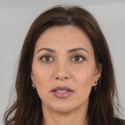 Joyful white adult female with long  brown hair and brown eyes