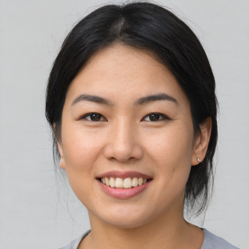 Joyful asian young-adult female with medium  brown hair and brown eyes