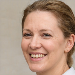 Joyful white adult female with medium  brown hair and blue eyes