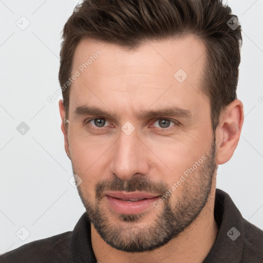 Joyful white adult male with short  brown hair and brown eyes