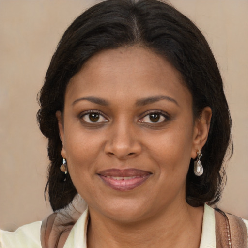 Joyful black young-adult female with long  brown hair and brown eyes