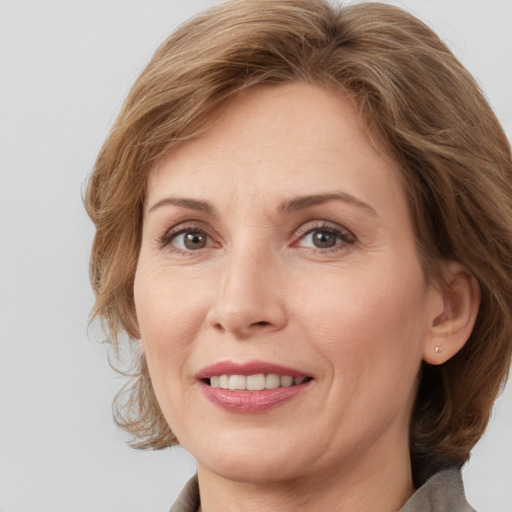 Joyful white adult female with medium  brown hair and grey eyes