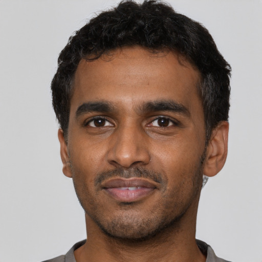 Joyful latino young-adult male with short  black hair and brown eyes