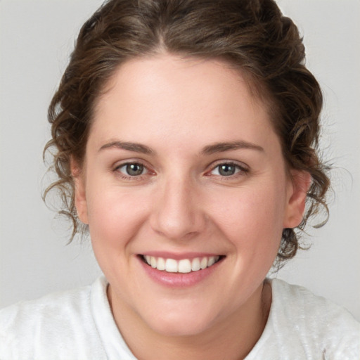 Joyful white young-adult female with medium  brown hair and blue eyes