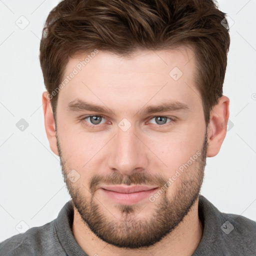 Joyful white young-adult male with short  brown hair and grey eyes