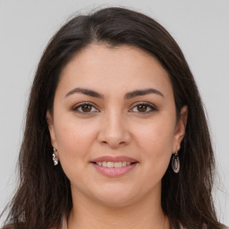 Joyful white young-adult female with long  brown hair and brown eyes