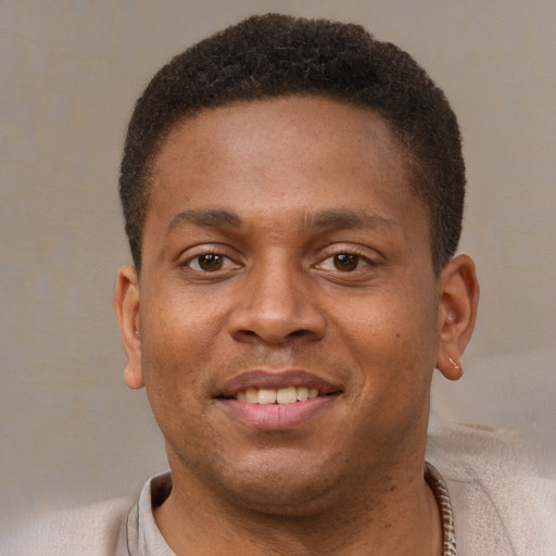 Joyful black young-adult male with short  brown hair and brown eyes