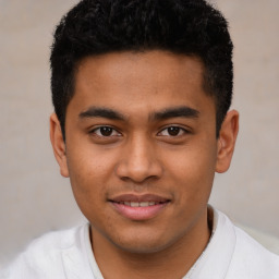 Joyful latino young-adult male with short  brown hair and brown eyes