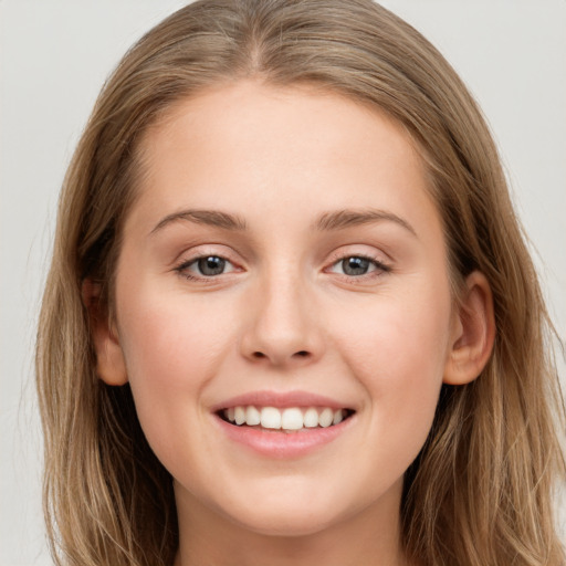 Joyful white young-adult female with long  brown hair and grey eyes