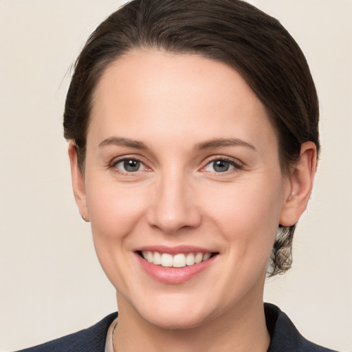 Joyful white young-adult female with medium  brown hair and grey eyes