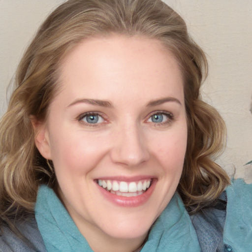 Joyful white young-adult female with medium  brown hair and blue eyes