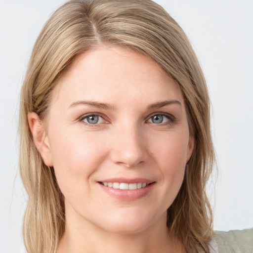 Joyful white young-adult female with long  brown hair and blue eyes