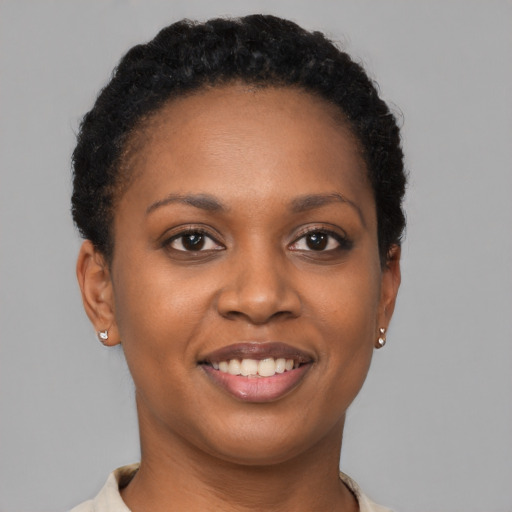 Joyful black young-adult female with short  brown hair and brown eyes
