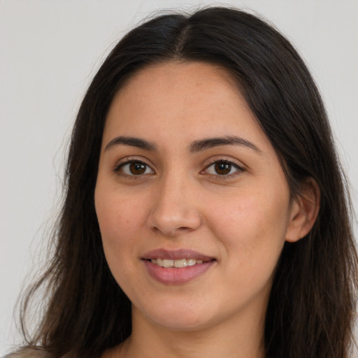 Joyful white young-adult female with long  brown hair and brown eyes