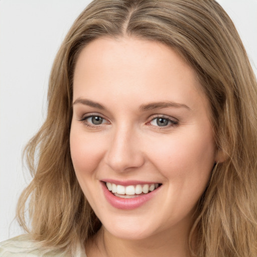 Joyful white young-adult female with long  brown hair and blue eyes