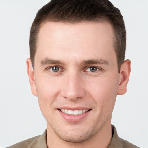 Joyful white young-adult male with short  brown hair and grey eyes