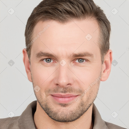 Joyful white young-adult male with short  brown hair and grey eyes