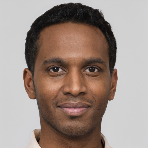 Joyful black young-adult male with short  black hair and brown eyes