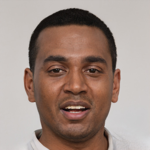 Joyful black young-adult male with short  black hair and brown eyes