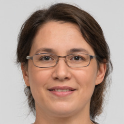 Joyful white adult female with medium  brown hair and grey eyes