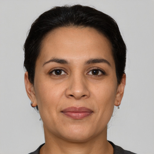 Joyful latino adult female with short  brown hair and brown eyes