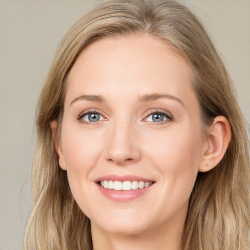 Joyful white young-adult female with long  brown hair and blue eyes