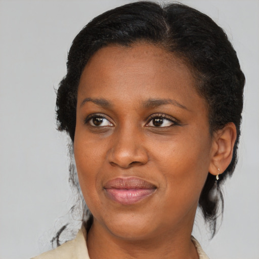 Joyful black adult female with medium  brown hair and brown eyes