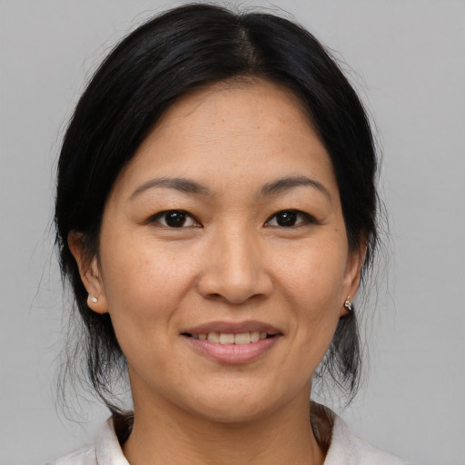 Joyful asian adult female with medium  black hair and brown eyes