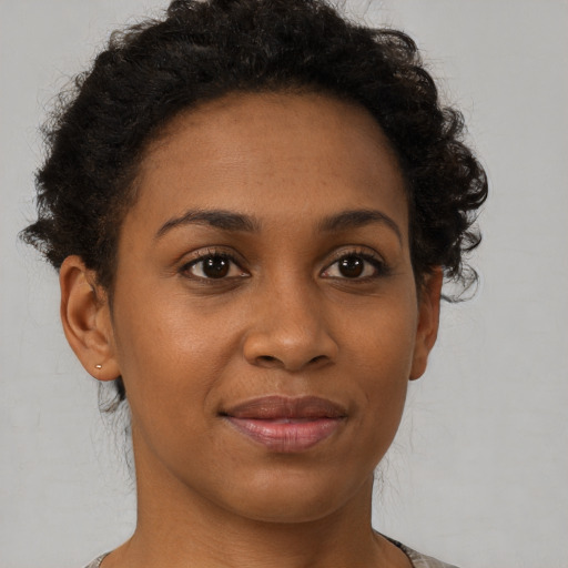 Joyful black young-adult female with short  brown hair and brown eyes