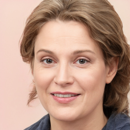 Joyful white adult female with medium  brown hair and blue eyes