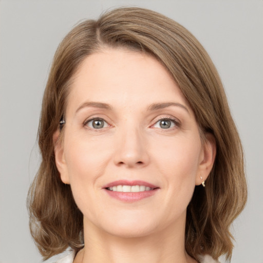 Joyful white young-adult female with medium  brown hair and grey eyes