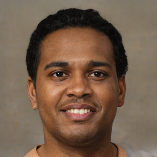 Joyful latino young-adult male with short  black hair and brown eyes