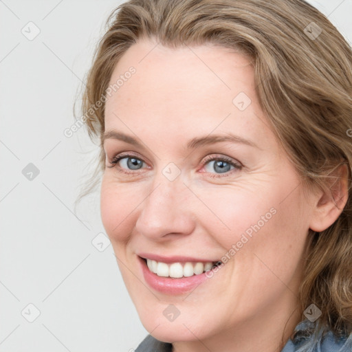 Joyful white adult female with medium  brown hair and blue eyes