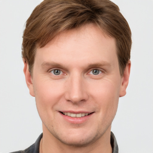 Joyful white young-adult male with short  brown hair and grey eyes