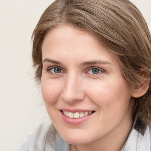 Joyful white young-adult female with medium  brown hair and blue eyes