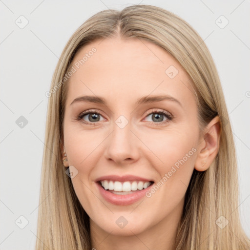 Joyful white young-adult female with long  brown hair and brown eyes