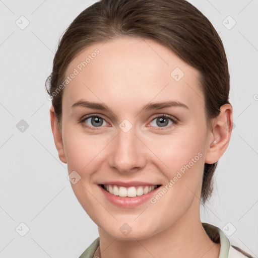 Joyful white young-adult female with medium  brown hair and grey eyes