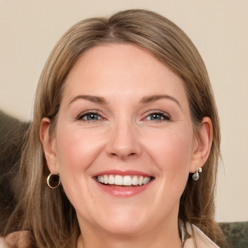 Joyful white adult female with medium  brown hair and grey eyes