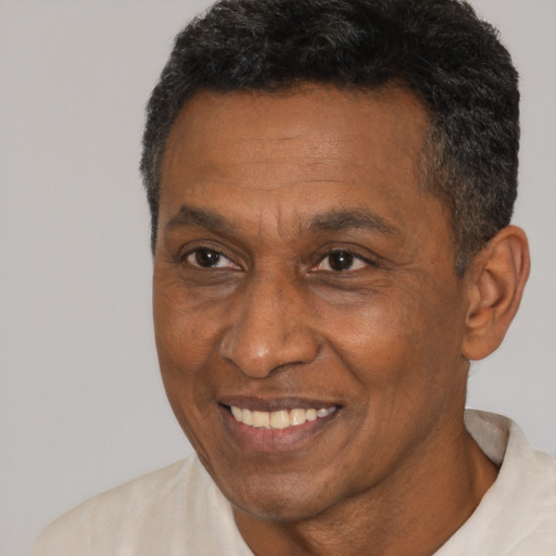 Joyful black adult male with short  brown hair and brown eyes