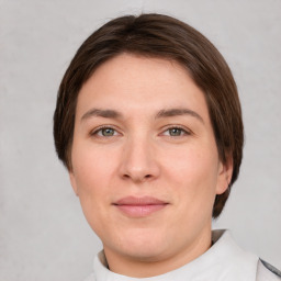 Joyful white young-adult female with medium  brown hair and green eyes