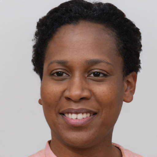 Joyful black young-adult female with short  black hair and brown eyes