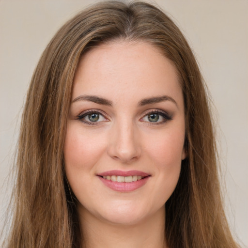 Joyful white young-adult female with long  brown hair and green eyes