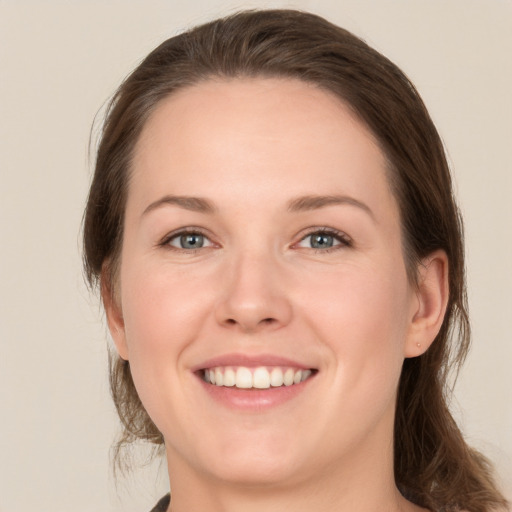 Joyful white young-adult female with medium  brown hair and green eyes