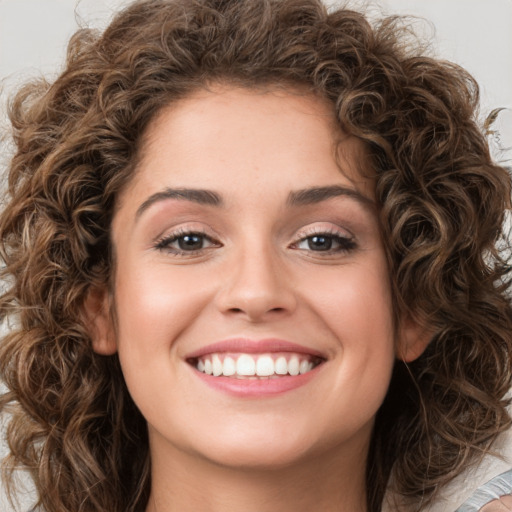 Joyful white young-adult female with medium  brown hair and green eyes