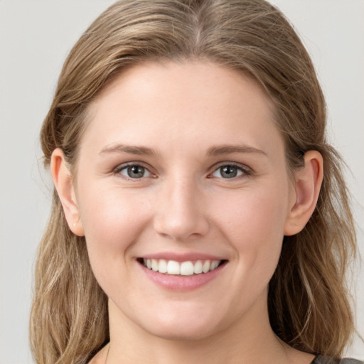 Joyful white young-adult female with medium  brown hair and grey eyes